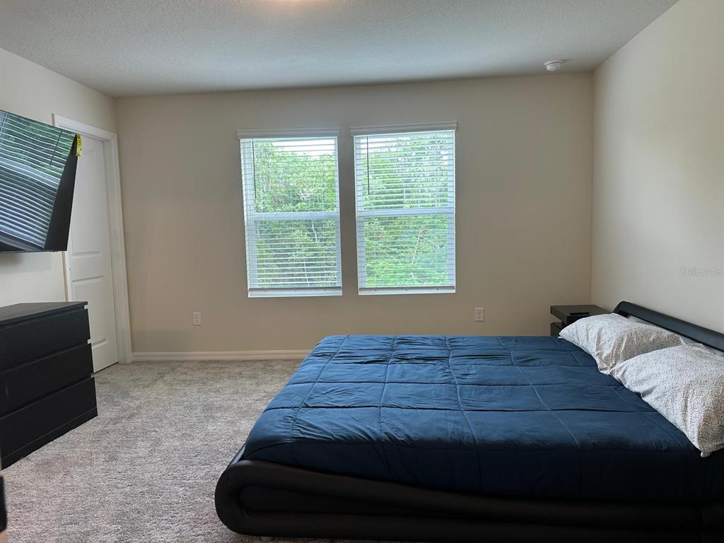 4669 Sparkling Shell Avenue Kissimmee, FL 34746 - Photo 9 of 21 a bed sitting in a bedroom next to a window