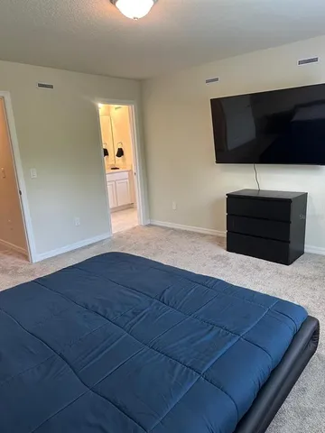 a living room with a bed furniture and a flat screen tv