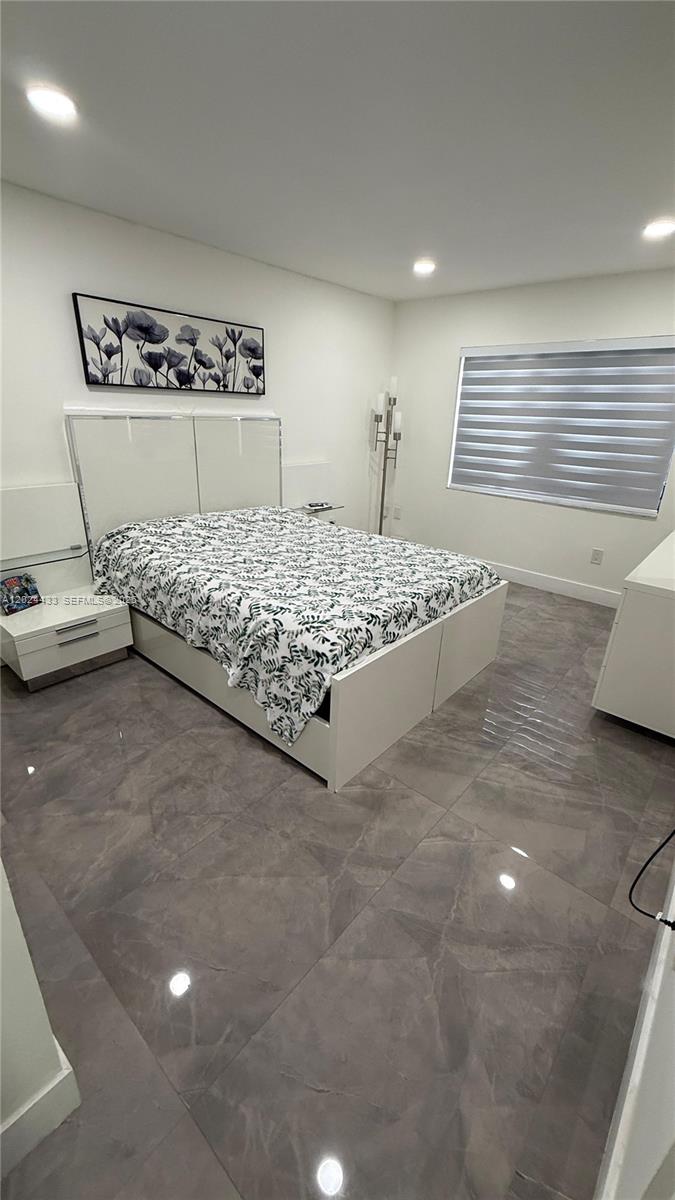 13675 Southwest 62nd Street, Unit 2023 Miami, FL 33183 - Photo 13 of 22 a bed sitting in a room next to a lamp