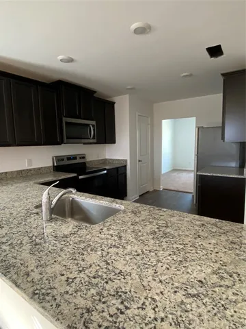 a view of a kitchen with a sink and a refrigerator