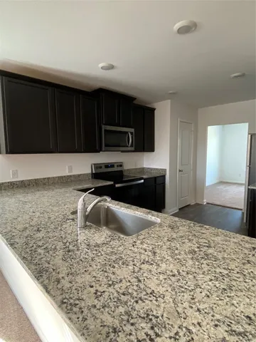 a kitchen with kitchen island sink and refrigerator