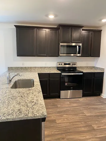 a kitchen with stainless steel appliances wooden cabinets and granite counter tops