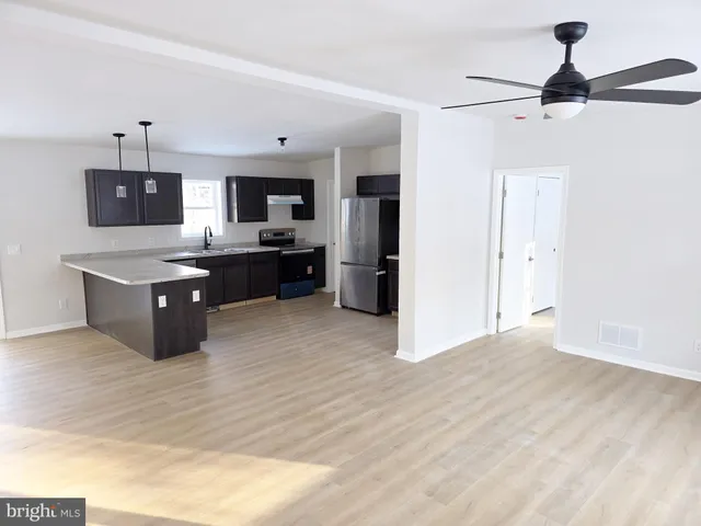 a living room with stainless steel appliances kitchen island furniture and a kitchen view