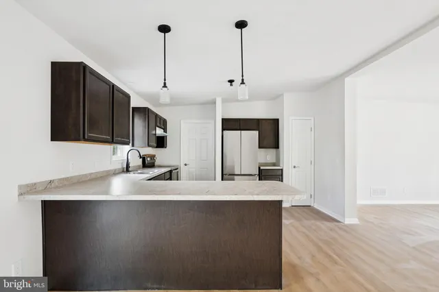 a large kitchen with kitchen island a sink stainless steel appliances and cabinets
