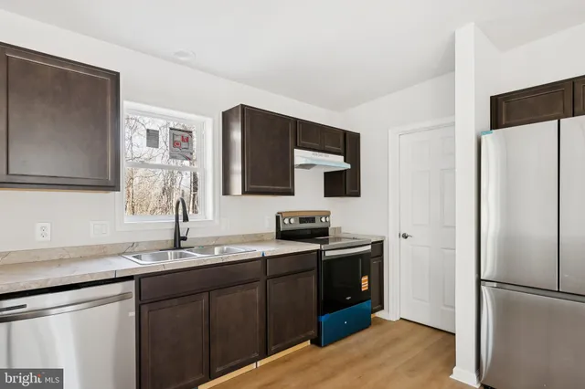 a kitchen with stainless steel appliances granite countertop a refrigerator and a sink
