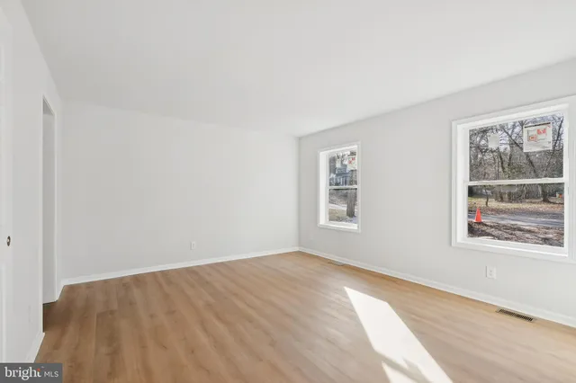 a view of a big room with wooden floor and windows