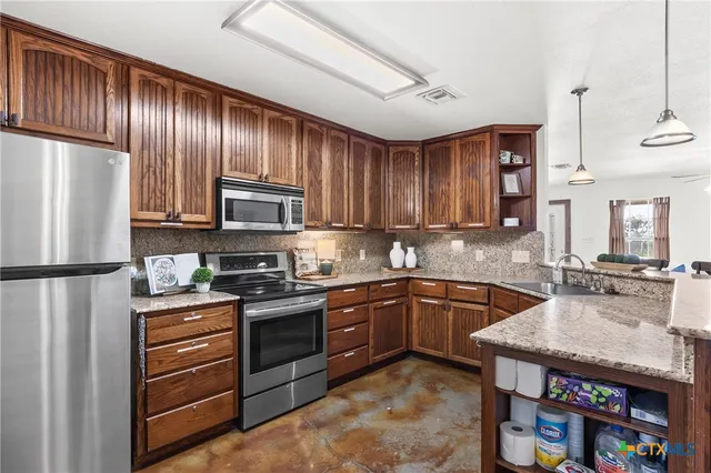 a kitchen with granite countertop stainless steel appliances and wooden cabinets