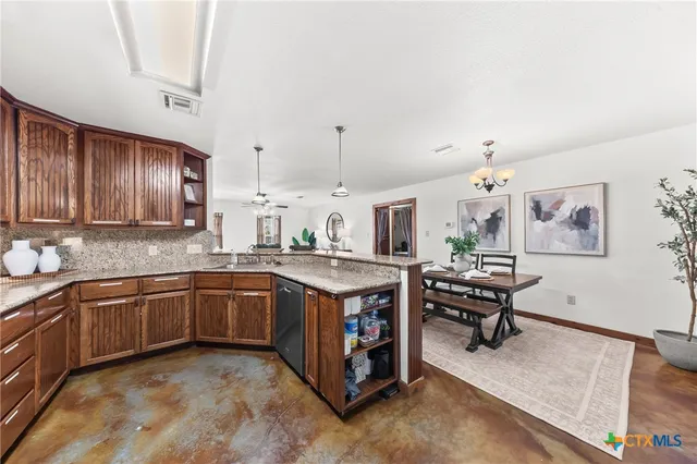 a kitchen with stainless steel appliances granite countertop a sink stove and cabinets