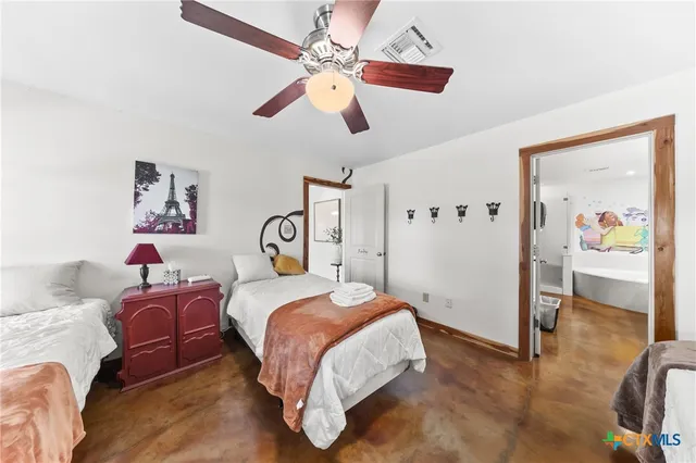 a spacious bedroom with a bed and a chandelier