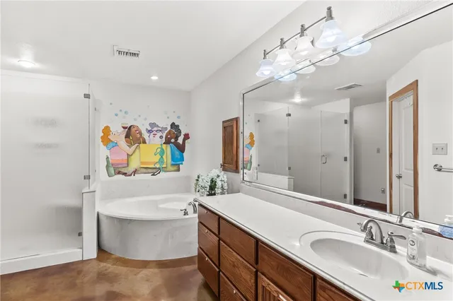 a bathroom with a sink a vanity a bathtub and a mirror