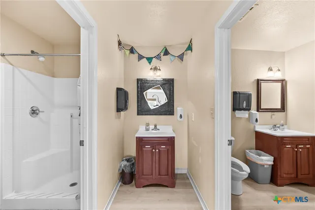 a bathroom with a granite countertop sink mirror vanity and a toilet