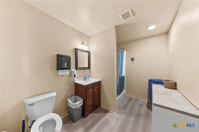 a bathroom with a toilet a sink and mirror