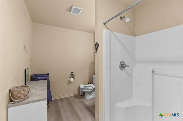 a bathroom with a sink a toilet and shower