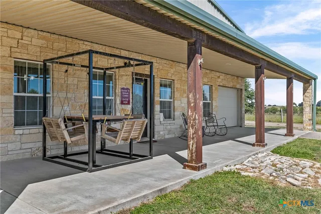 a view of a porch with chairs and backyard