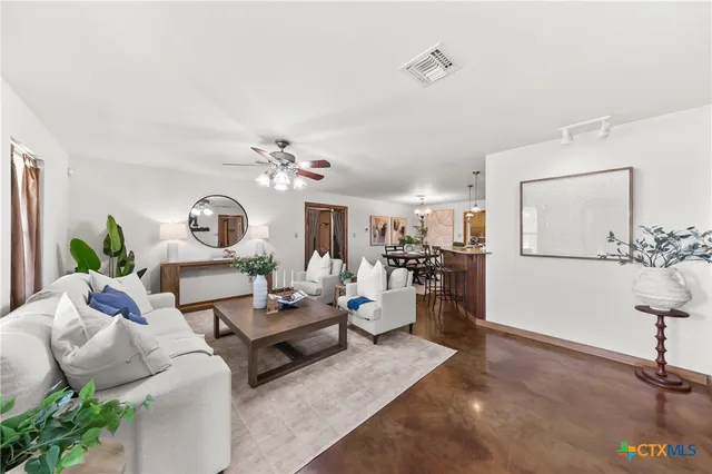 a living room with furniture and a wooden floor