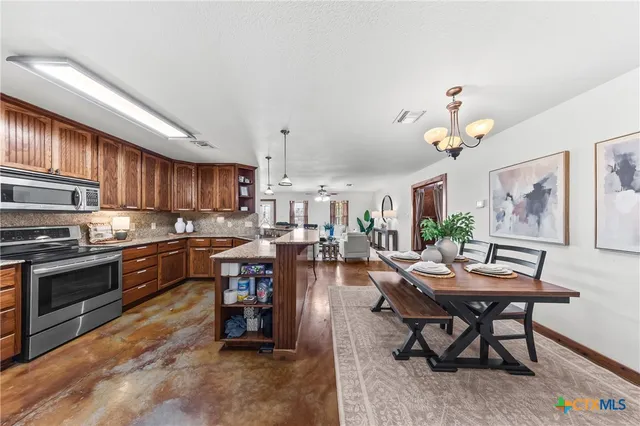 a kitchen with a table chairs stove and cabinets
