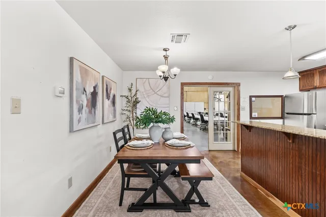 a view of a dining room with furniture and a chandelier