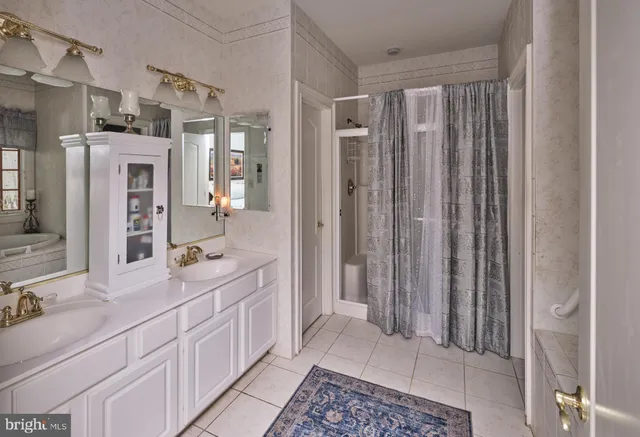 a bathroom with a granite countertop tub sink and mirror