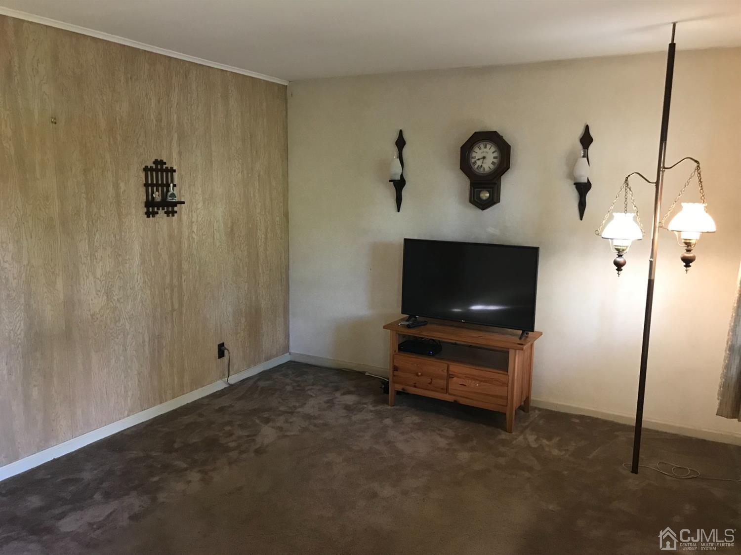 137 Milltown Road East Brunswick, NJ 08816 - Photo 7 of 22 a living room with a flat screen tv and a wall painting