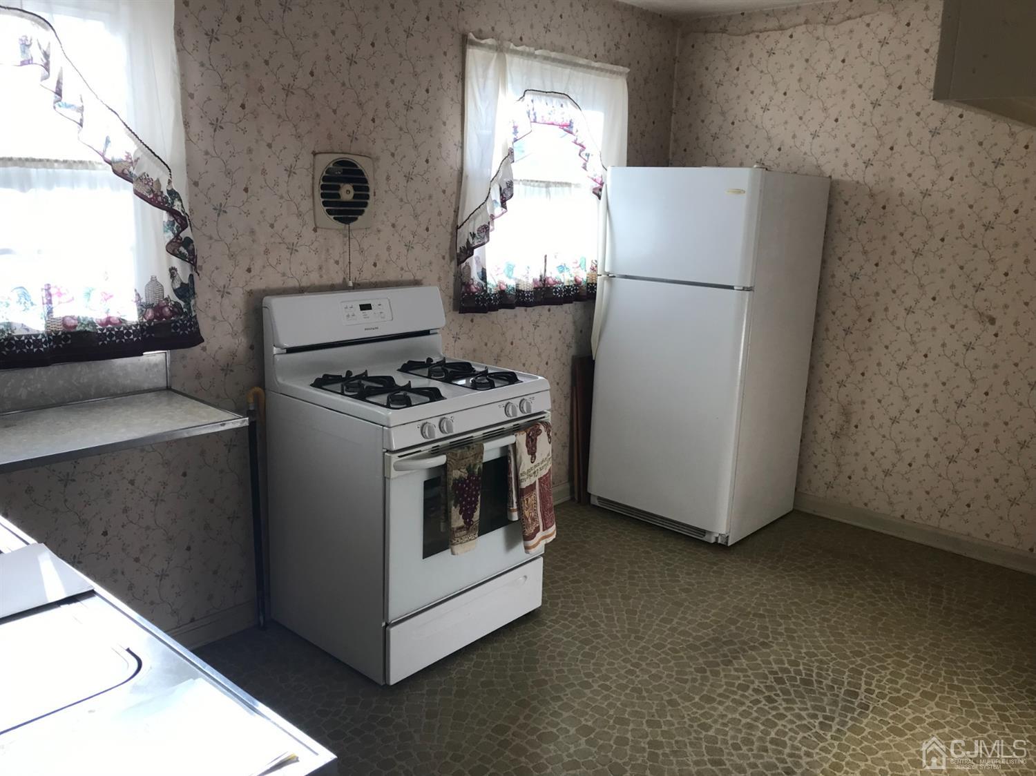 137 Milltown Road East Brunswick, NJ 08816 - Photo 9 of 22 a kitchen with a stove and a refrigerator