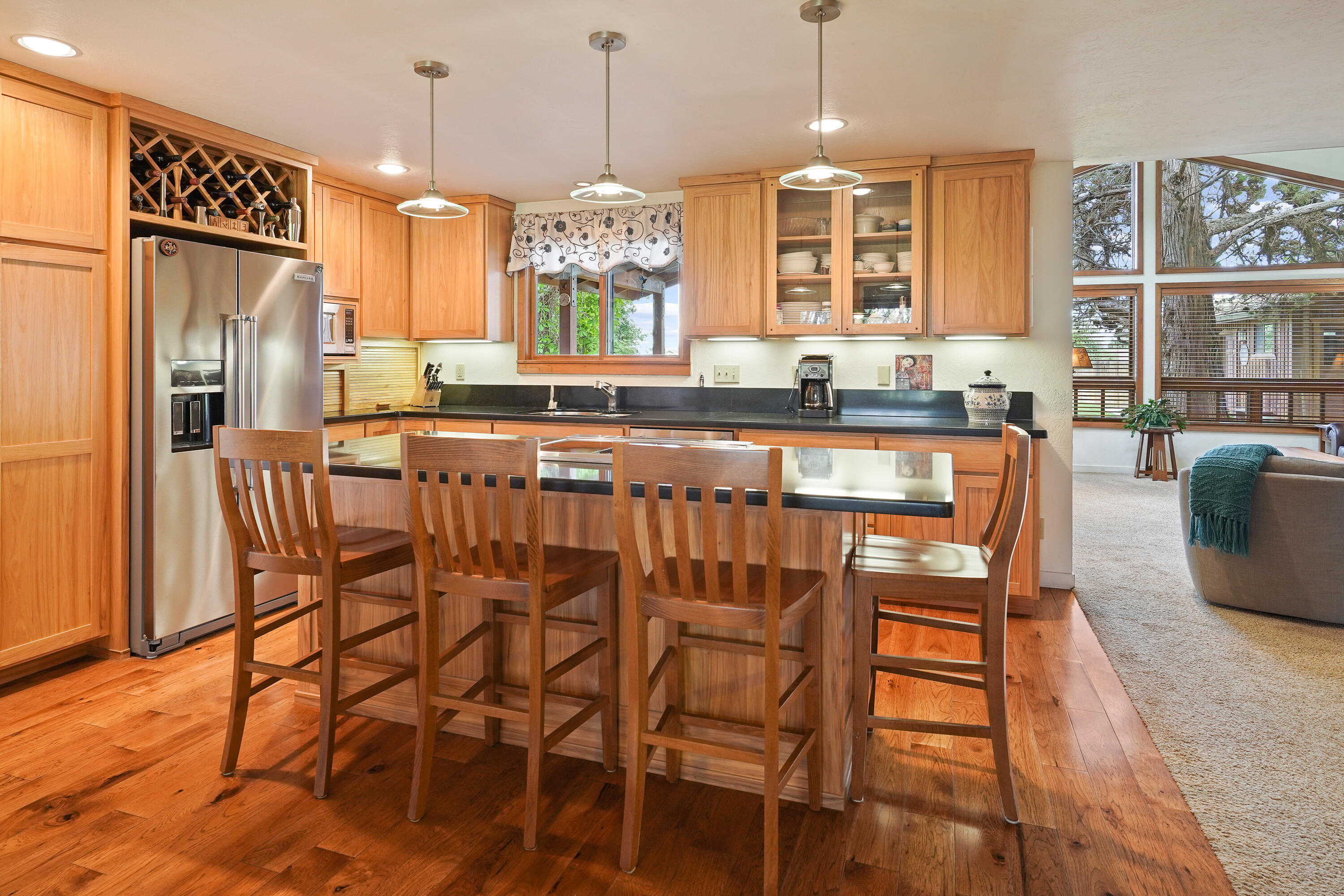 62636 Erickson Road Bend, OR 97701 - Photo 11 of 47 a kitchen with granite countertop a table chairs stove microwave and refrigerator