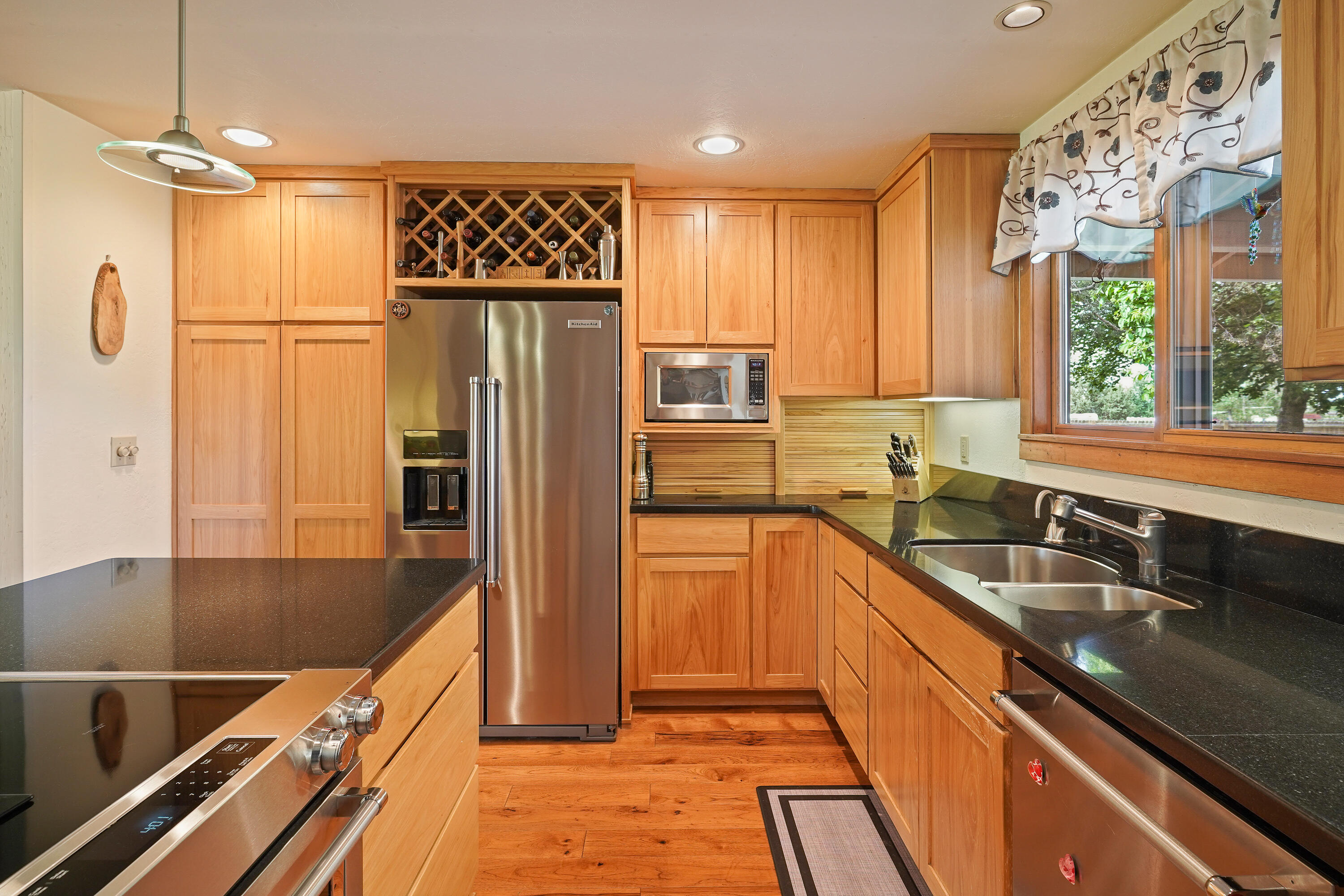 62636 Erickson Road Bend, OR 97701 - Photo 12 of 47 a kitchen with stainless steel appliances granite countertop a refrigerator a sink and white cabinets