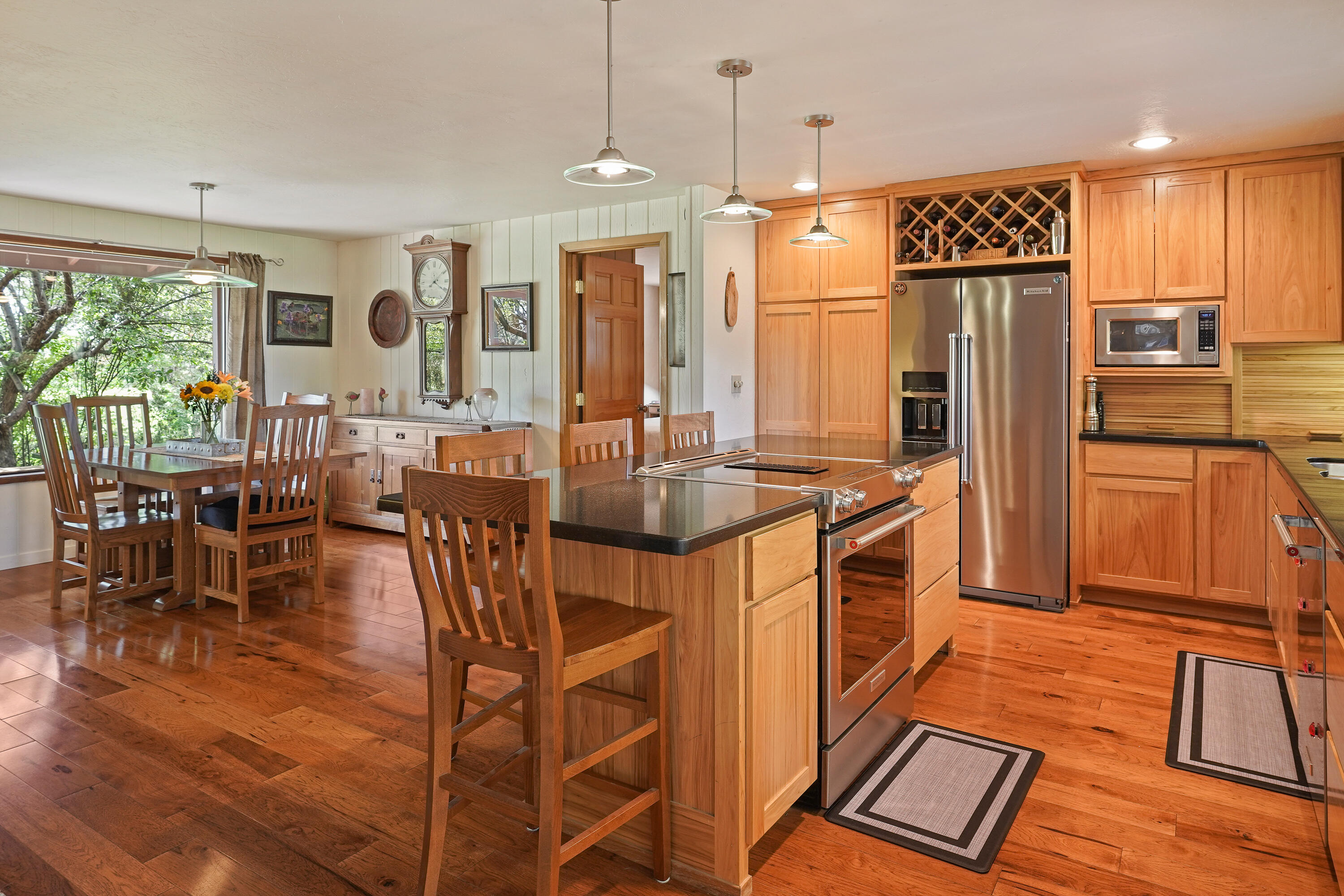 62636 Erickson Road Bend, OR 97701 - Photo 10 of 47 a kitchen with stainless steel appliances granite countertop a refrigerator a sink a stove and chairs with wooden floor