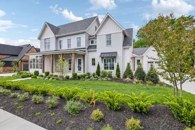 a front view of a house with a yard and trees