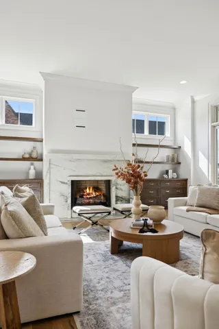 a kitchen with stainless steel appliances kitchen island granite countertop a dining table chairs and a refrigerator