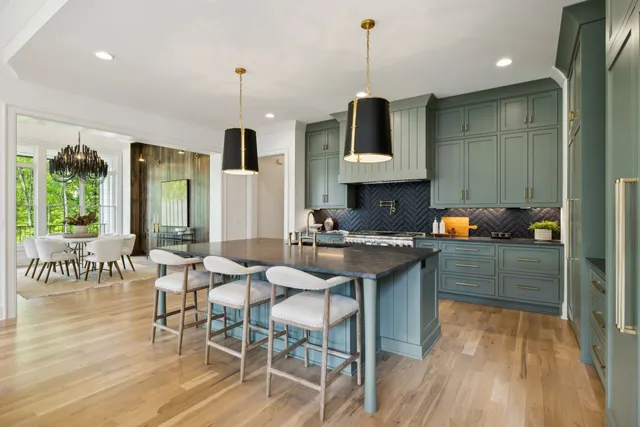 a kitchen with stainless steel appliances granite countertop a sink a stove and a wooden floors