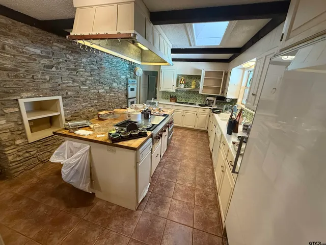 a kitchen with stainless steel appliances granite countertop a stove a sink dishwasher and a refrigerator