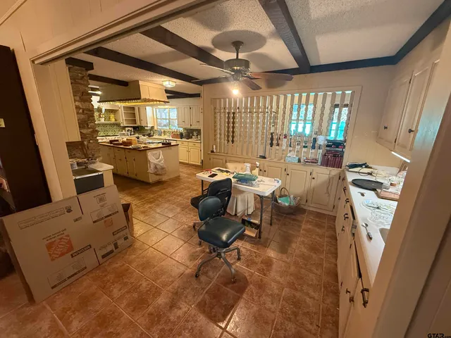 a living room with furniture and a view of kitchen