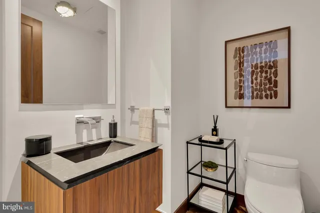 a bathroom with a sink a toilet and mirror