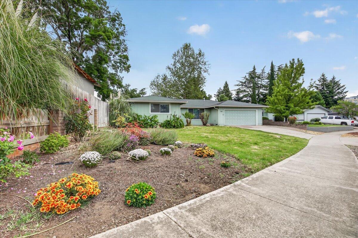 a front view of a house with a yard and a garden