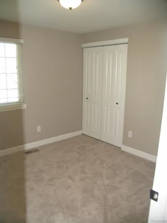 an empty room with windows and closet