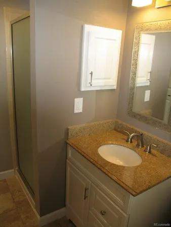 a bathroom with a granite countertop sink and a mirror