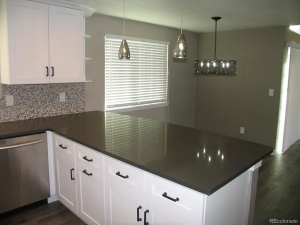 a kitchen with granite countertop a sink and cabinets