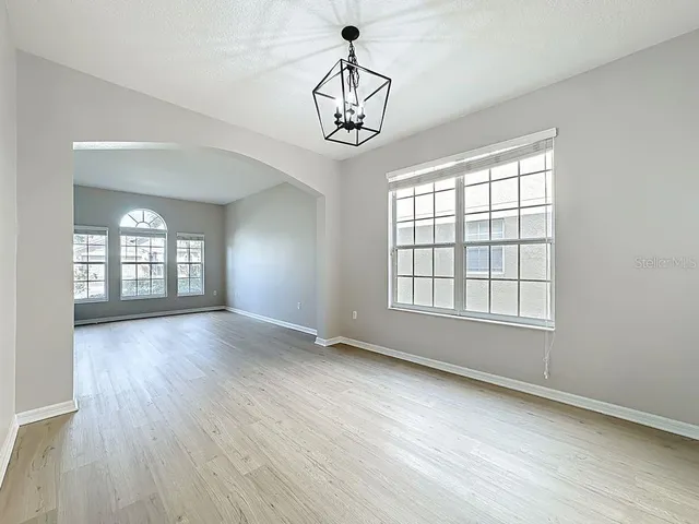 a view of a big room with wooden floor and windows