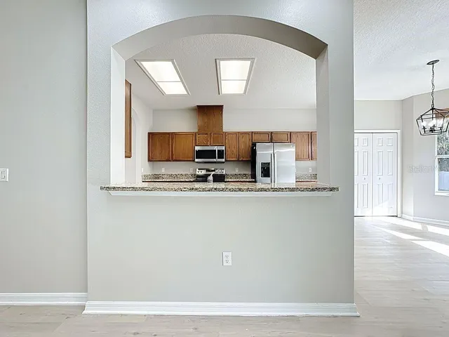 an empty room with closet and a chandelier fan