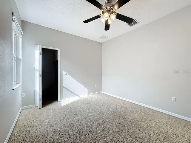 a view of a livingroom with a ceiling fan and window