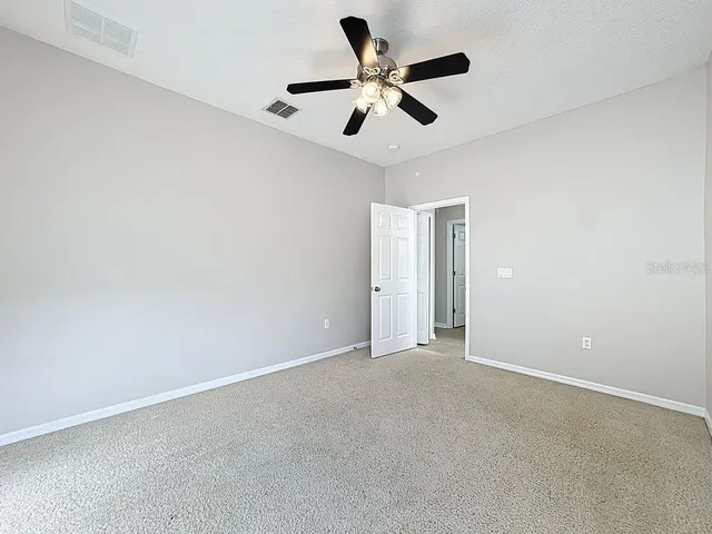 a view of a room with a ceiling fan and a window