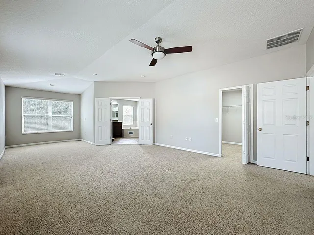 a bathroom with a granite countertop sink a toilet a mirror and a tub