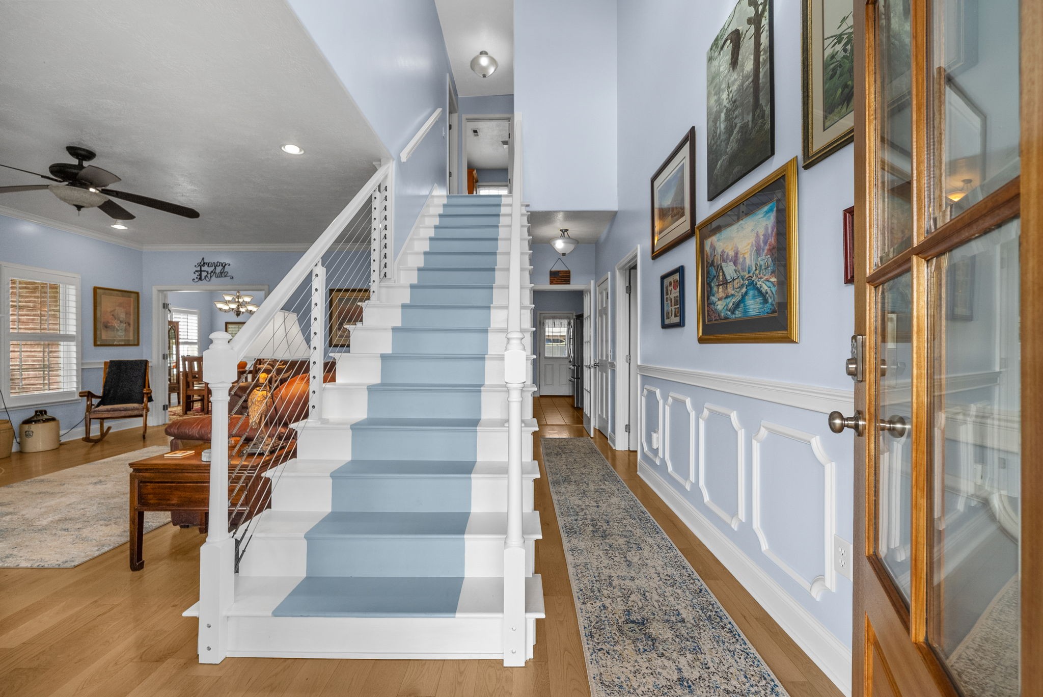 3989 Cadiz Road Bumpus Mills, TN 37028 - Photo 8 of 97 a view of staircase with lots of frames on wall and a rug