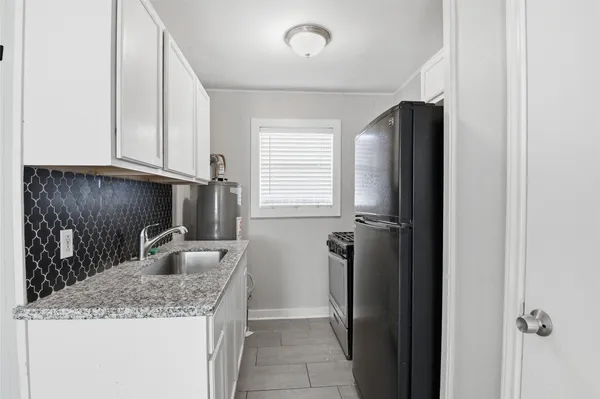 a kitchen with granite countertop a refrigerator and a sink