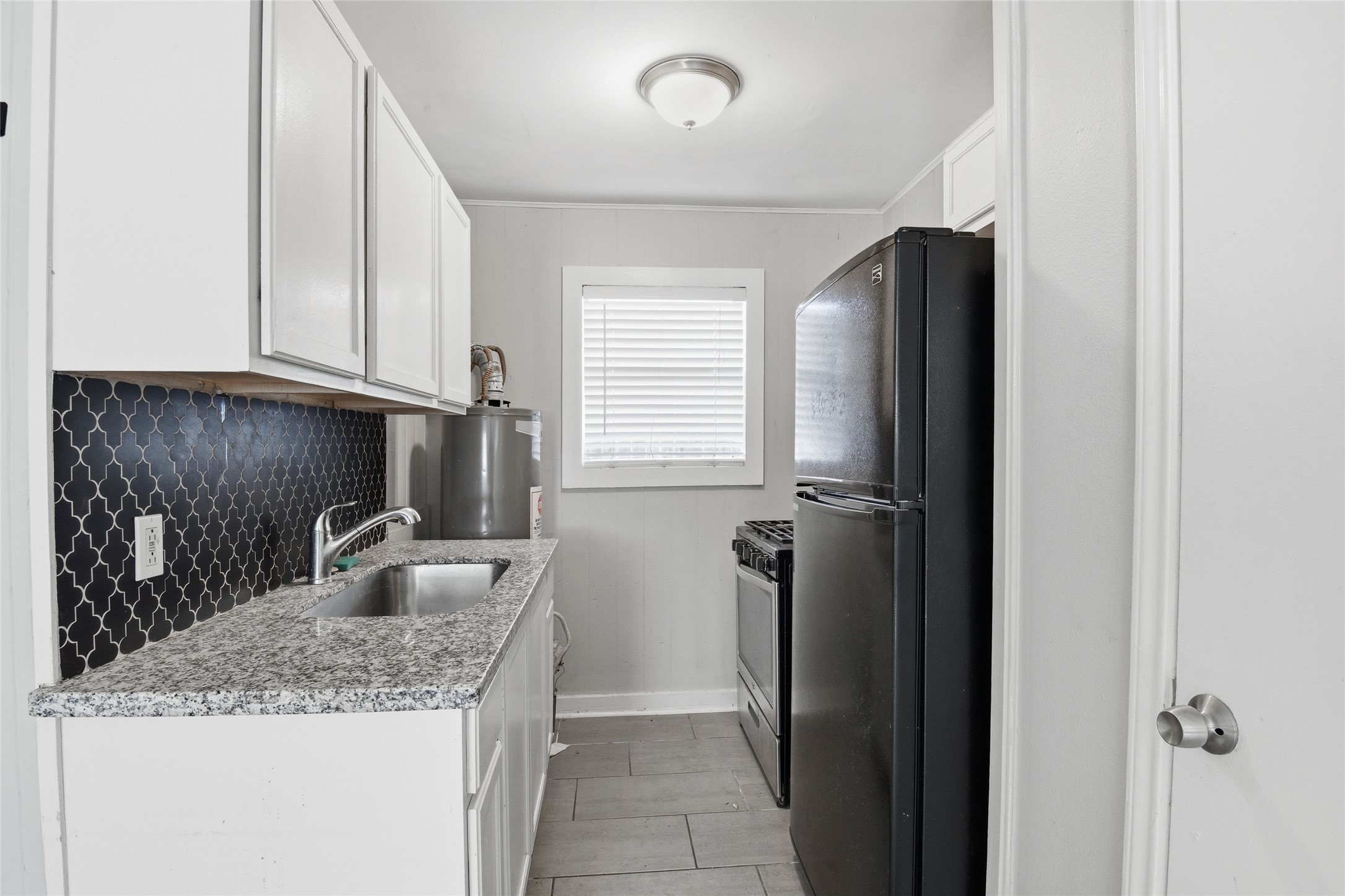 5010 Ennis Street, Unit 3 Houston, TX 77004 - Photo 6 of 12 a kitchen with granite countertop a refrigerator and a sink