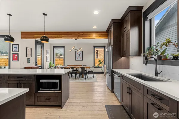a kitchen with stainless steel appliances granite countertop a sink and a refrigerator