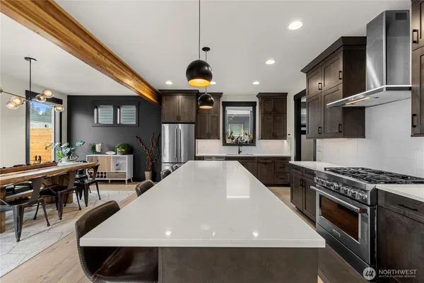 a kitchen with stainless steel appliances a stove a sink dishwasher and cabinets with wooden floor