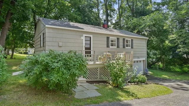 a view of a house with brick walls and a yard with plants