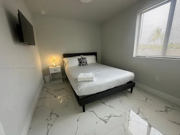 a bedroom with a bed and flat screen tv