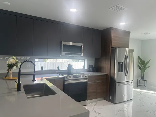 a kitchen with stainless steel appliances a refrigerator sink and cabinets